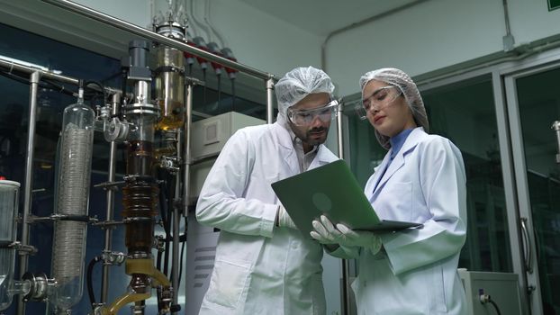 Two scientist in professional uniform working in laboratory for chemical and biomedical experiment