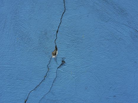 Abstract background from old damaged plaster with cracks.Texture of cracks on blue plaster.