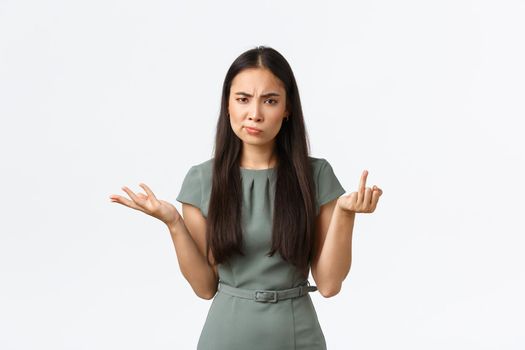 Small business owners, women entrepreneurs concept. Confused and displeased asian woman cant understand why boyfriend not making proposal, showing finger without wedding ring and shrugging.