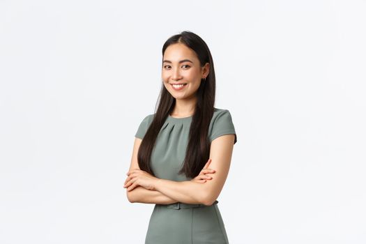 Small business owners, women entrepreneurs concept. Successful confident asian businesswoman in dress, cross arms and looking pleased at camera, smiling, managing store or internet site.