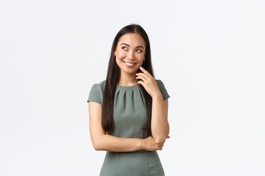 Small business owners, women entrepreneurs concept. Creative thoughtful, attractive asian businesswoman have idea, imaging something in bubble, looking upper left corner and smiling pleased.