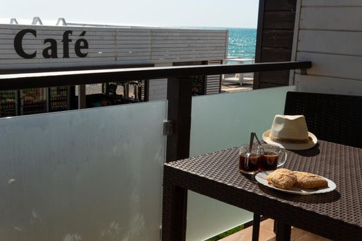 RUSSIA, CRIMEA - JUL 04, 2022: Caf sea restaurant buns coffee cup sky summer table blue, concept enjoying life in drink for view espresso, ocean beverage. Sunny relaxation wooden