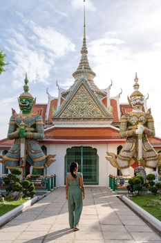 Wat Arun temple Bangkok Thailand, Temple of Dawn, Buddhist temple alongside Chao Phraya River.Beautiful Wat Arun at dusk evening sunset, Asian woman visiting temple