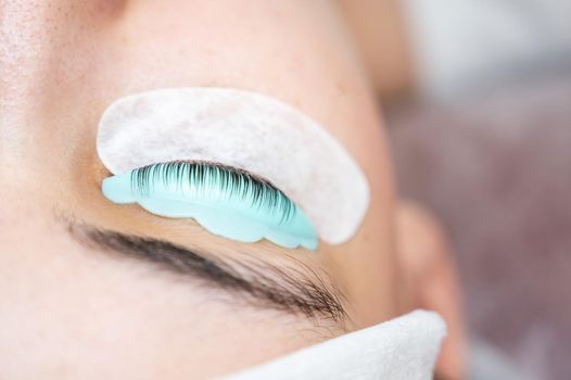 Close-up portrait of a woman in a beauty salon on eyelash lamination procedure