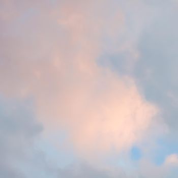 Background of blue sky with pale pink clouds at sunset