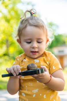 The child looks at the snail. Selective focus. Animal.