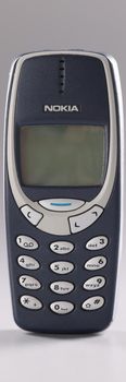 Minsk, Belarus, December 08, 2021: Cell phone Nokia 3310 blue on gray background. Old obsolete wireless phone concept