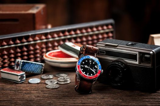 closeup luxury wristwatch for men with black dial blue-red bezel and leather strap.