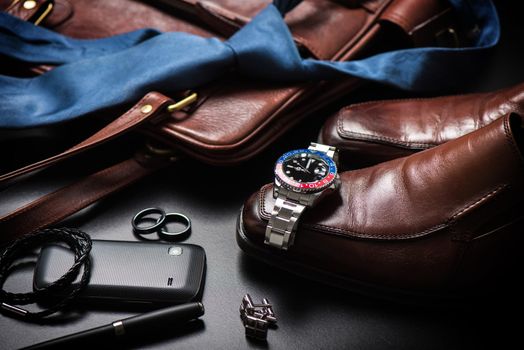 men's accessories, closeup at wristwatch with black dial blue-red bezel and stainless steel bracelet.