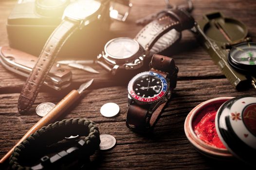 closeup luxury wristwatch for men with black dial blue-red bezel and leather strap. wristwatch with vintage men's objects.