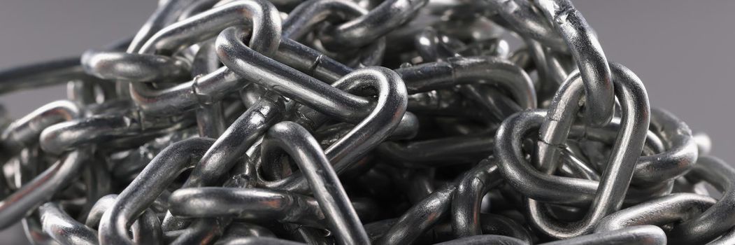 Chrome plated metal chain on gray background. Strong metal chain chain links concept