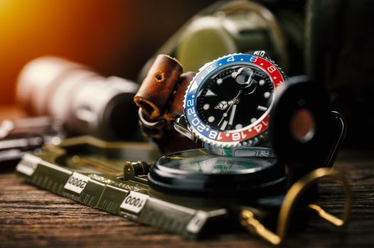 closeup luxury wristwatch for men with black dial blue-red bezel and leather strap. wristwatch with vintage men's objects.