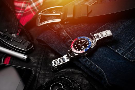 closeup luxury wristwatch for men with black dial blue-red bezel and stainless steel bracelet.