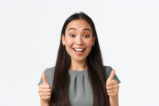Impressed supportive female asian friend showing thumbs-up, compliment great work, smiling amazed, pleased with good job, say well done or praise amazing effort, standing white background.