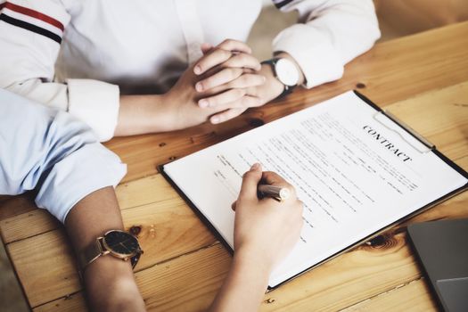 Business owner holding a pen to read the conditions to enter into a joint venture contract with a partner company