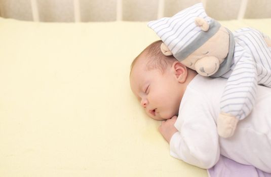 The baby sleeps in the copy space crib . Advertising of children's goods. Illustrating children's articles. A small child. A newborn. A child's dream.