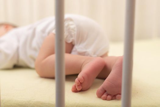 The baby sleeps in the copy space crib . Advertising of children's goods. Illustrating children's articles. A small child. A newborn. A child's dream.