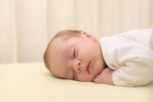 The baby sleeps in the copy space crib . Advertising of children's goods. Illustrating children's articles. A small child. A newborn. A child's dream.