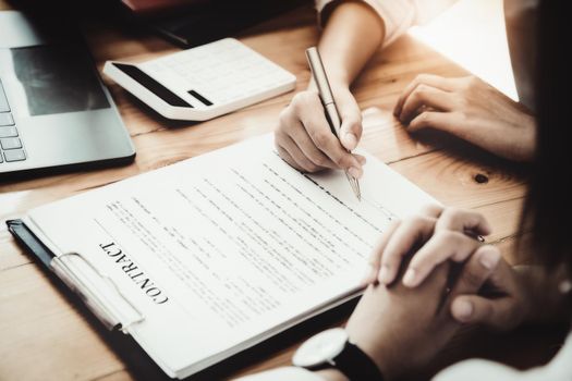 Business owner holding a pen to read the conditions to enter into a joint venture contract with a partner company