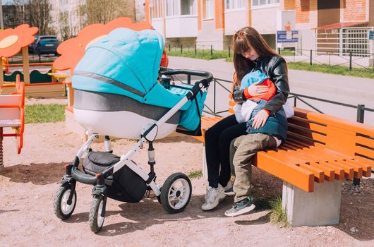 Mom on a walk with children lifestyle . An article about walking with children. An article about jealousy of a new child. Mom's vacation.