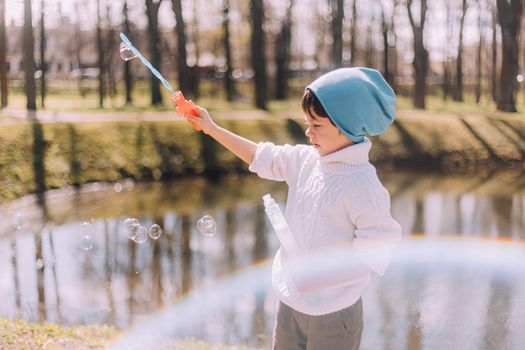 The boy blows soap bubbles lifestyle . Children's entertainment. Children's portrait. Article about children's leisure