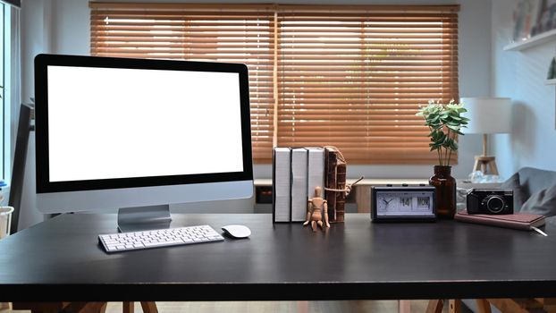 Mock up computer with white screen on black table in modern home office.