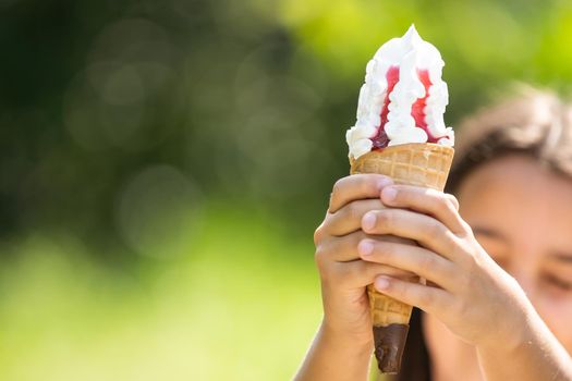 Pretty little girl eating an ice cream outdoors