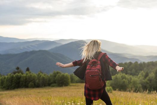 a woman rests after a hike in the mountains.