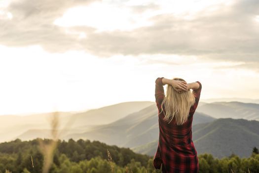 a woman rests after a hike in the mountains.