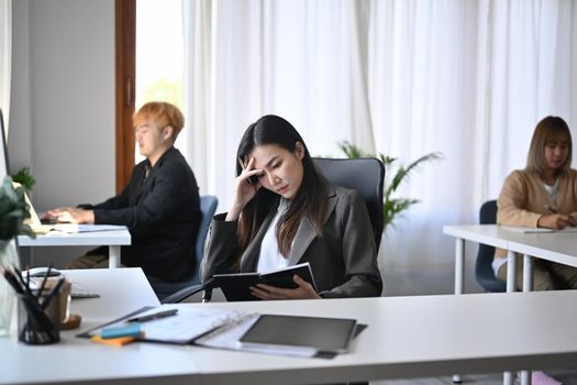 Young asian businesswoman suffering stress working at office.