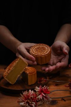 Close up view hands holding Chinese traditional mooncake. Mid Autumn festival and Chinese traditional festival concept.