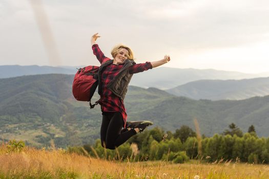 a woman rests after a hike in the mountains.