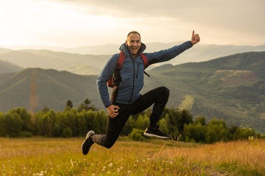 Young man enjoying the view on the top of the mountain. Carpathian mountains, Ukraine.