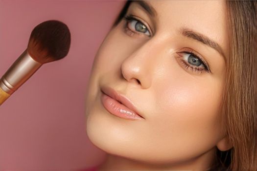 Beautiful young woman applying cosmetic powder product with make-up bamboo brush, beauty, makeup and skincare cosmetics model face portrait on pink background, closeup