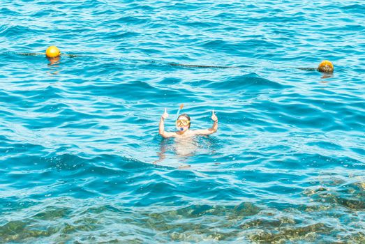 young girl is enjoying diving in the blue sea. High quality photo