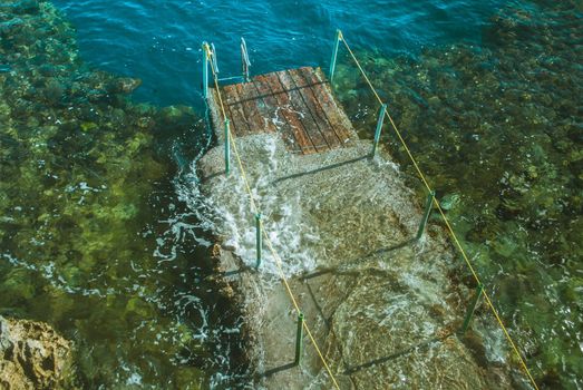 wooden pier in the sea with waves. High quality photo