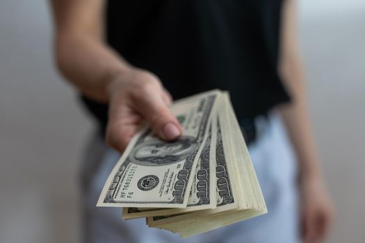 young girl isolated over white wall background holding money