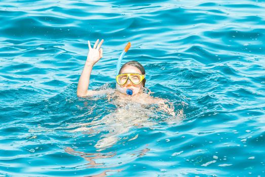 young girl is enjoying diving in the blue sea. High quality photo