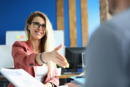 Businesswoman extends her hand for handshake when meeting with partners. Business arrangement and successful deal