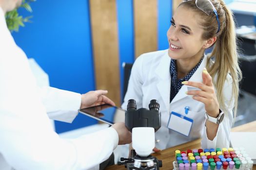 Physician scientists colleagues smile and communicate in laboratory. Learning and scientific experiments concept