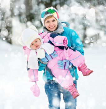 Happy and beautiful mother with her small child on a winter walk