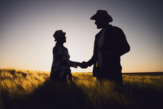 Partnership in agricultural business. Couple working together as farmers and cultivating wheat.