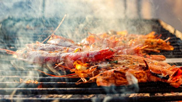 Grilled shrimp (Giant freshwater prawn) grilling with charcoal. Grilled shrimp on a grill with charcoal grill. Close-up of shrimps being fried in oil pan