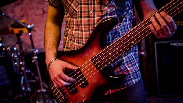 Detail man hands play an acoustic guitar live rock band performance on the stage