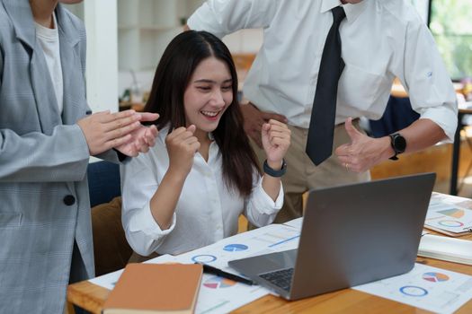 A portrait of three Asian business showing joy from sales of new projects that meet customer demand.