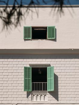 Wooden light green shutters on the window of a typical white house on the island of Ibiza, Spain. Vertical shot.