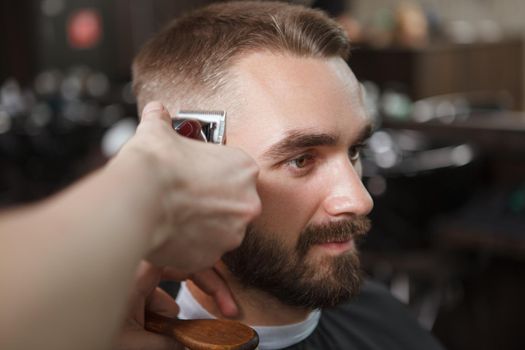 Close up of a handsome man getting a new haircut at the barbershop