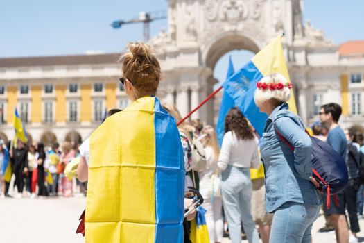 Portugal, Lisbon April 2022: The demonstration on Commerce Square in support of Ukraine and against the Russian aggression. Protesters against Russia's war Many people with Ukrainian flags. Crowd