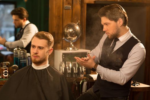 Shot of a handsome professional barber powdering his hands examining new haircut of his client after cutting his hair copyspace service people lifestyle hipster vintage classic traditional styling.