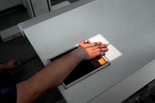 Top view of the hand of a patient on top of an x-ray plate in an hospital